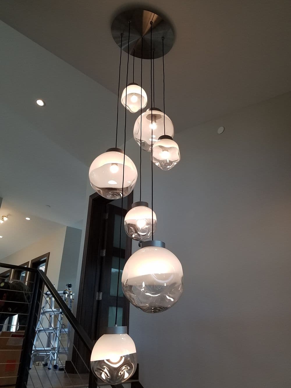 Modern pendant lights in varying sizes hanging from a ceiling in a stylish interior.