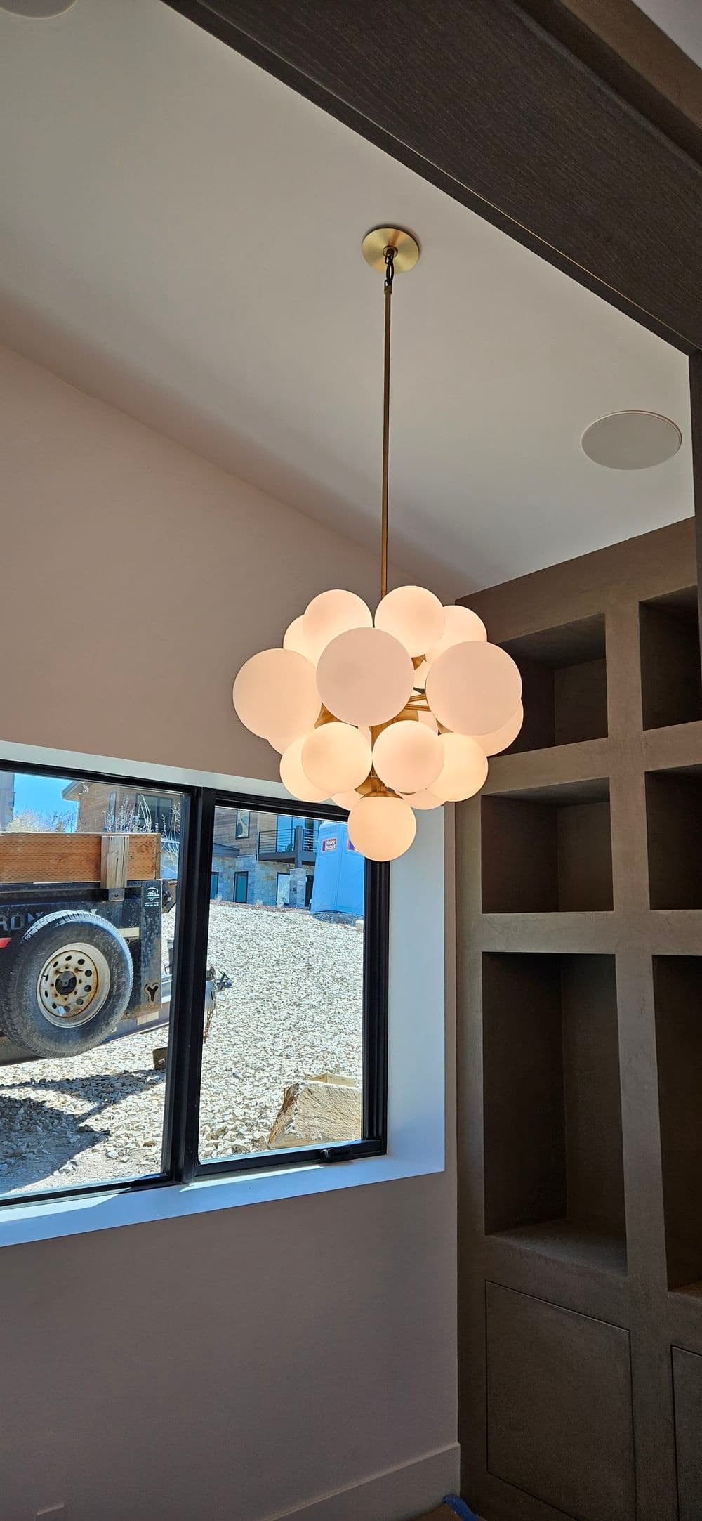 Modern pendant light fixture with spherical white bulbs in a contemporary interior space.