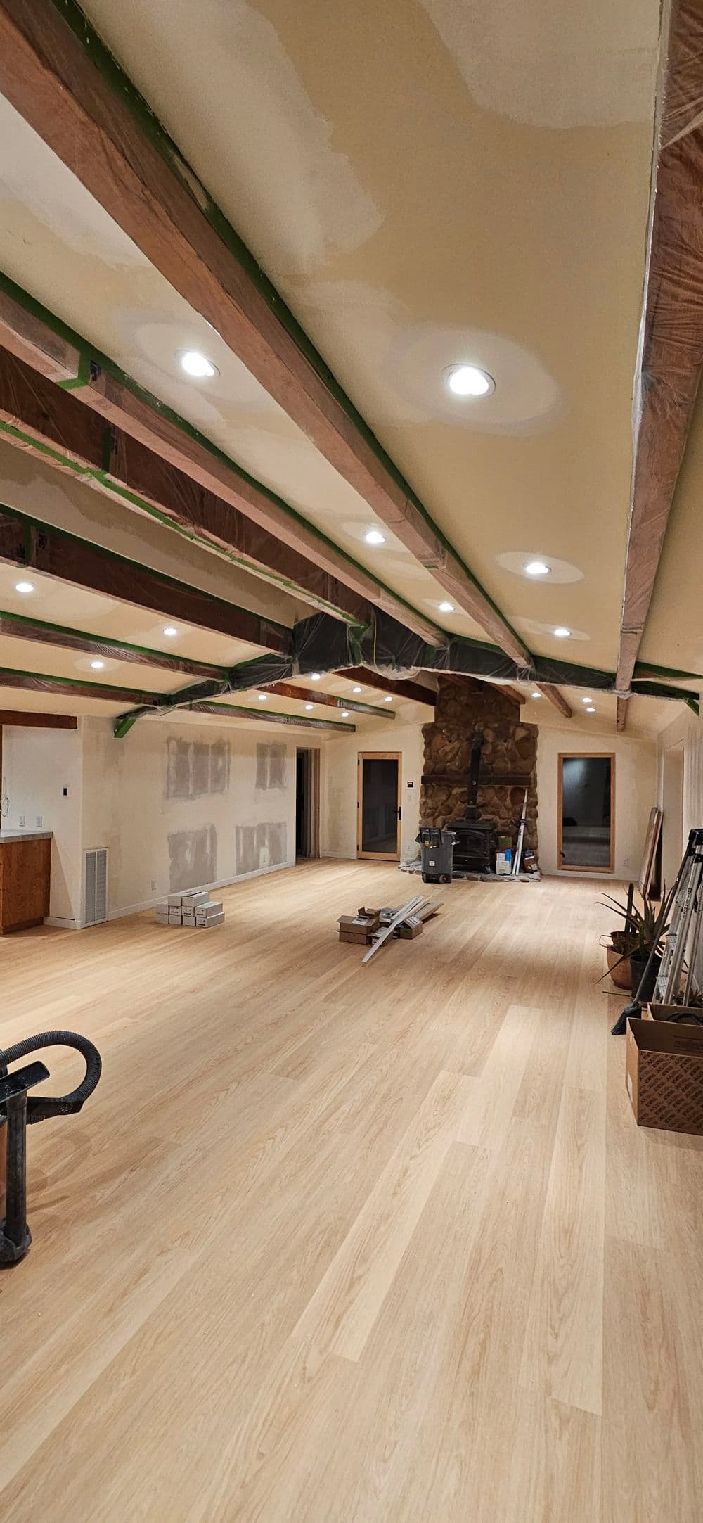 Renovated interior space with wooden beams, new flooring, and modern lighting.